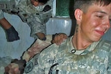 A US soldier poses with the body of a dead Afghan insurgent.