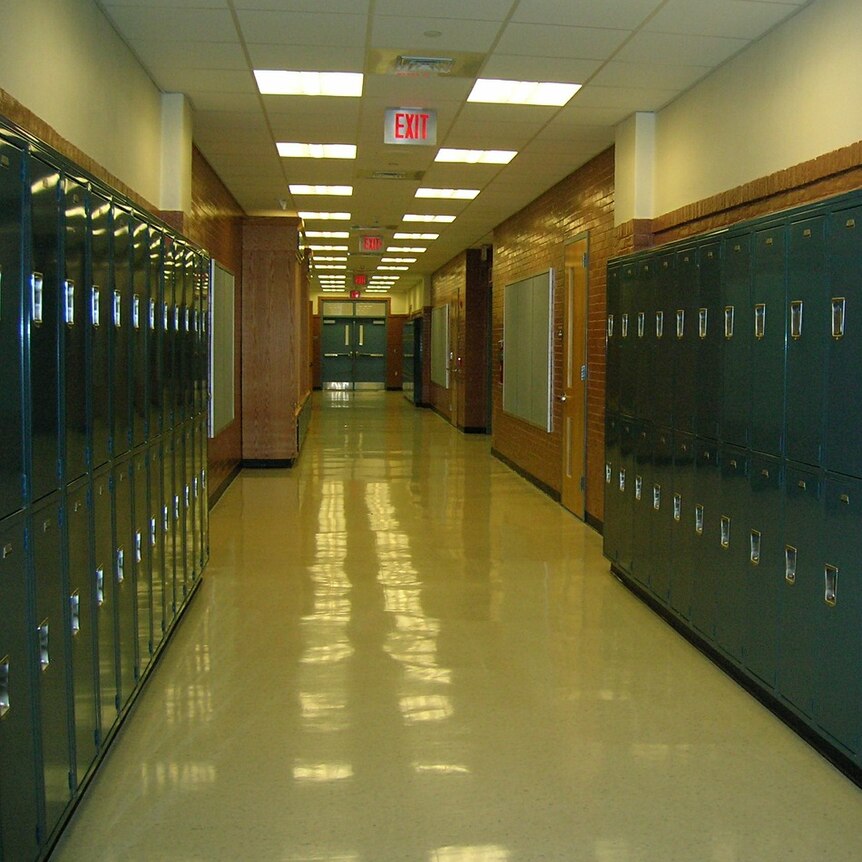 An empty school hallway with lockers on both sides.