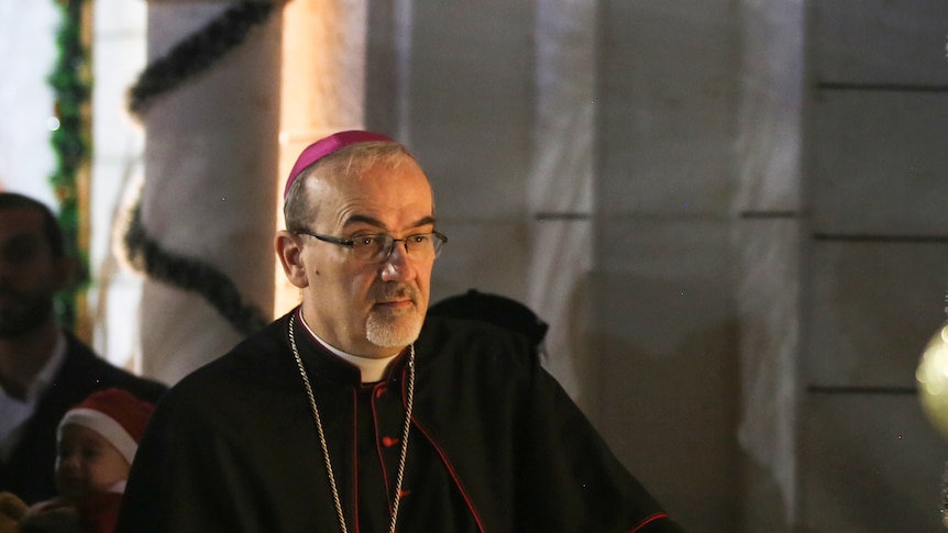 Cardinal Pierbattista Pizzaballa in black catholic robes gazes down