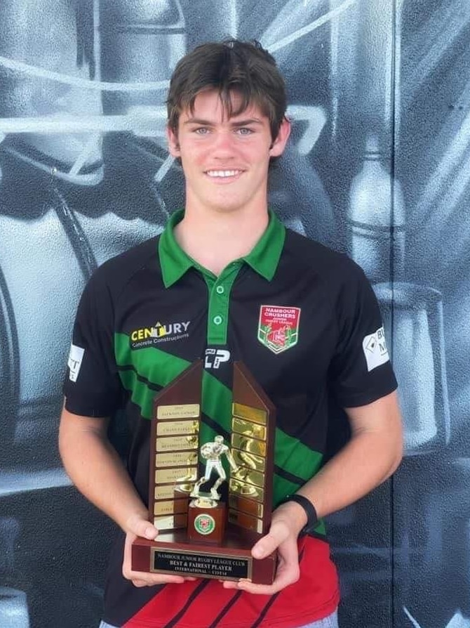 a teenage boy holding a trophy