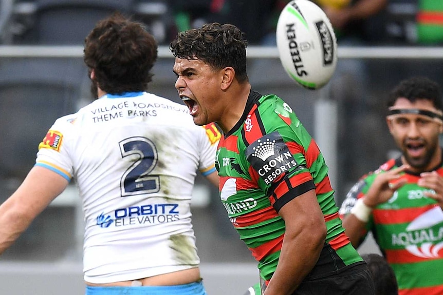 Latrell Mitchell screams as the ball bounces up in the air behind him after scoring a try for the Rabbitohs against the Titans.