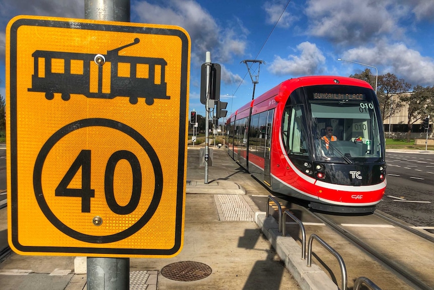 A light rail vehicle sits at an intersection in Canberra.