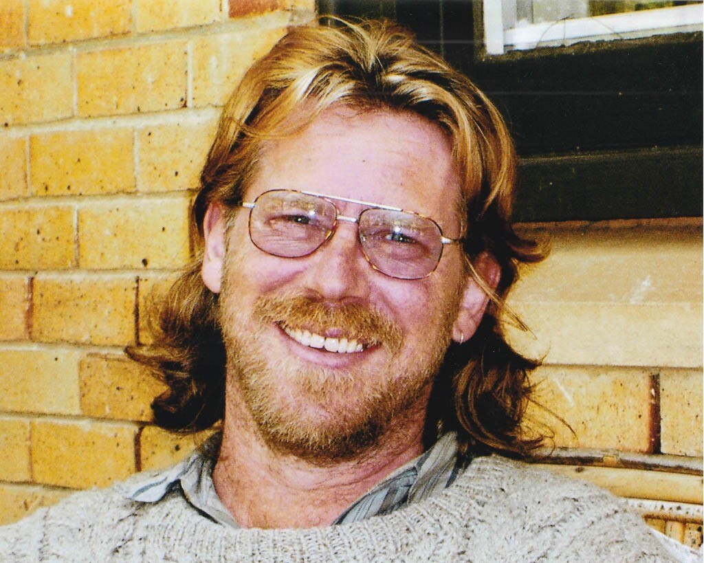 A man in glasses smiles at the camera.
