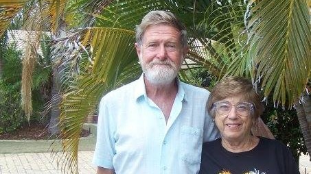 Joan and David Fensom stand within a bunch of palm trees