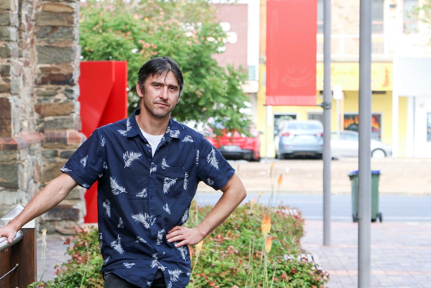 A man stands in a city laneway