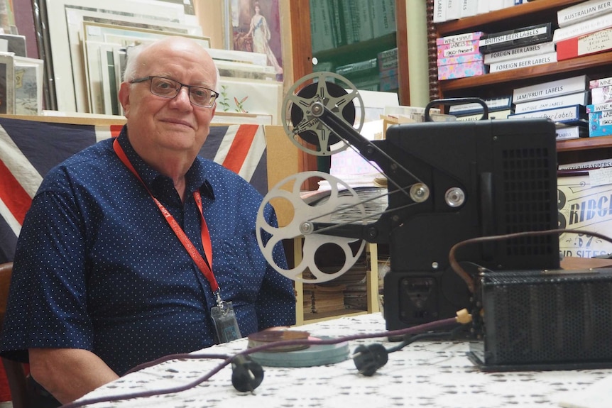 Antique dealer Phil Sunman surrounded by film and other antiques.