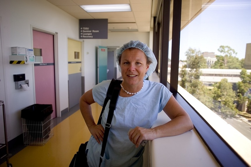 Fiona Wood dressed in scrubs on a hospital balcony.