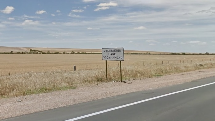 The Augusta Highway alongside bare paddocks.