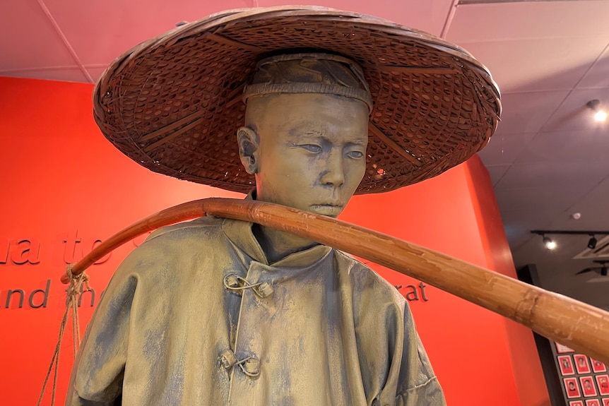 A closeup of a lifelike sculpture of a Chinese miner at the Gum San centre