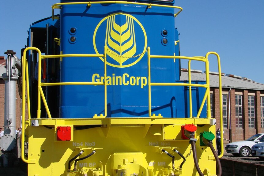 The front of a brightly coloured train with the name Graincorp painted on it with the company's logo  It's been freshly painted.