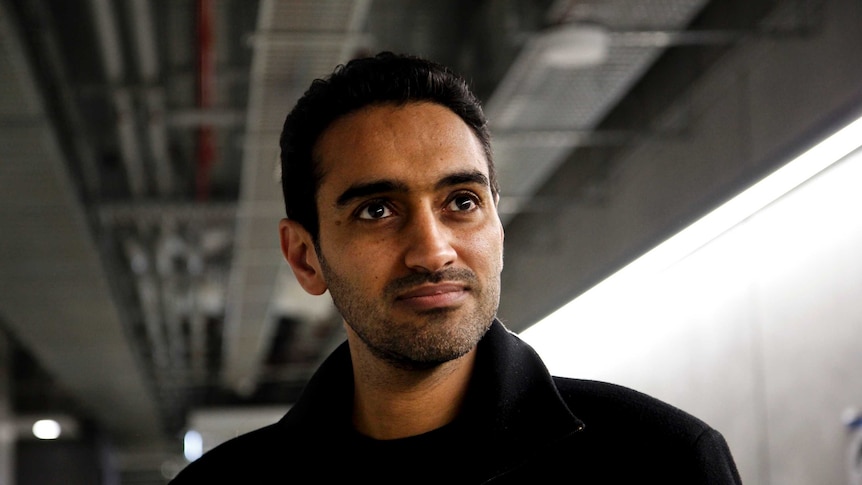 Waleed Aly stands in a tunnel as he stares into the distance.