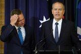 Chris Bowen scratches his head as Bill Shorten unveils his plans at a press conference