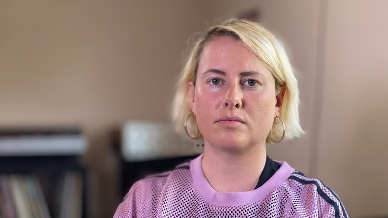 A woman looks at the camera with a stern look