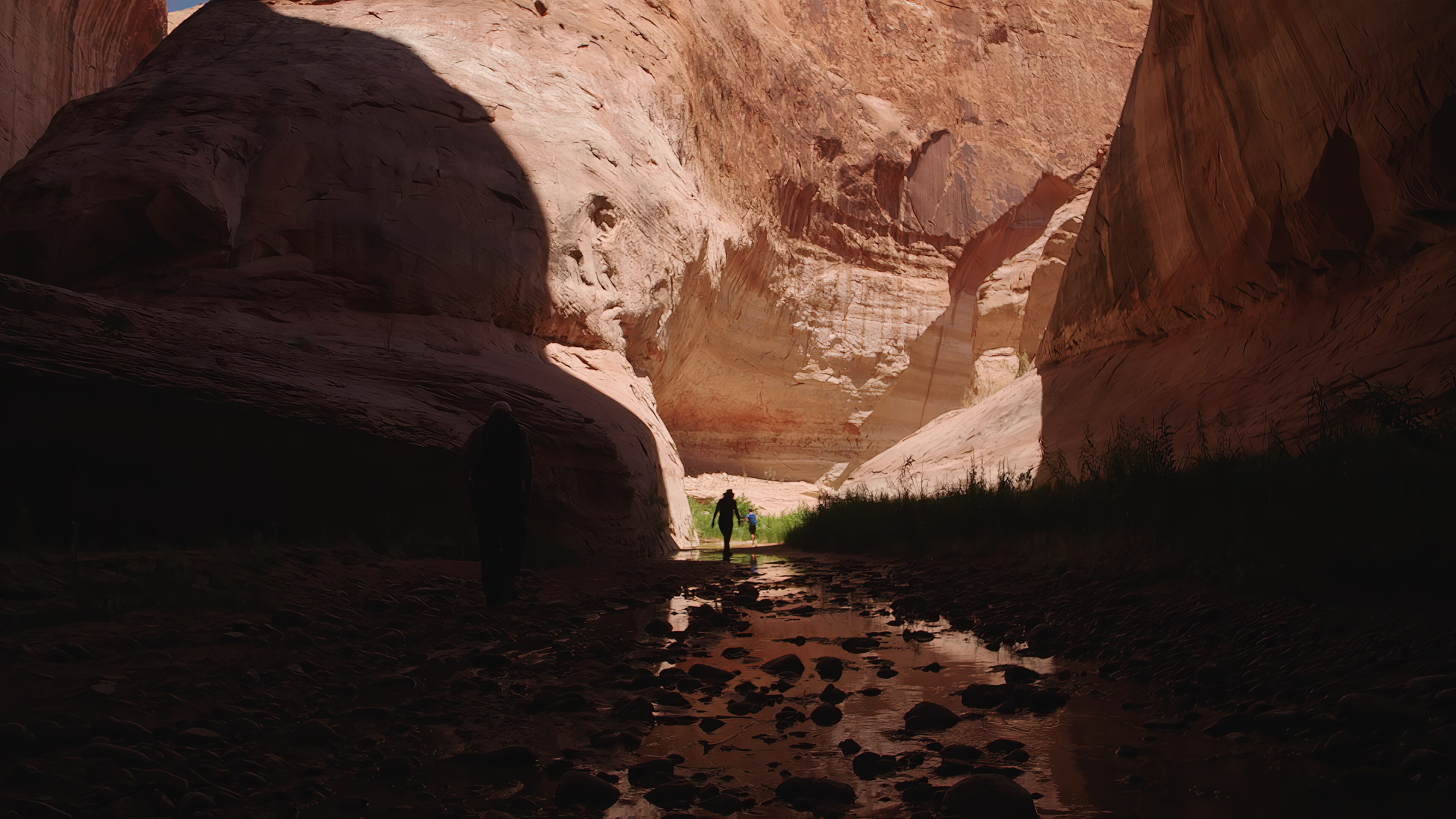 A woman walks through a canyon.