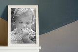 Black and white photo of a young girl in a photo frame for a story about an adoptee tracing down her birth mother.