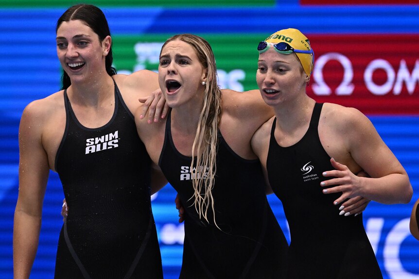 Three Australia female swimmers cheer on during the final of the women's 4x100m freestyle relay final.