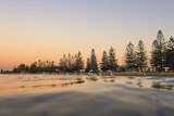 The sun rises over Altona beachfront, with pinks and oranges reflecting on the water