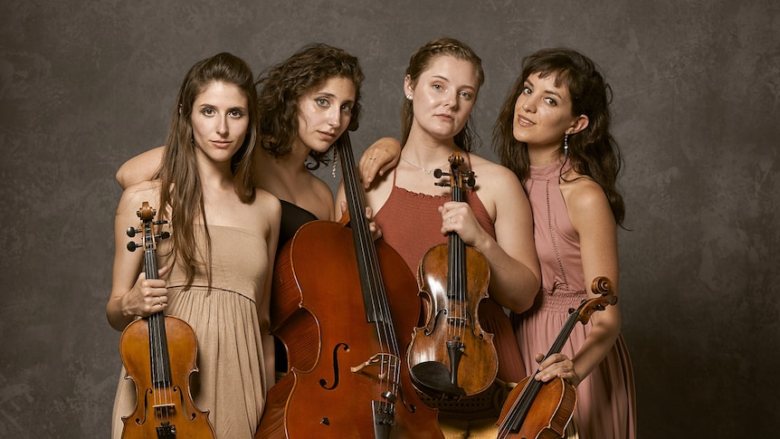 A photograph of the ATLYS string quartet, where the four women of the ensemble pose together, holding their instruments.