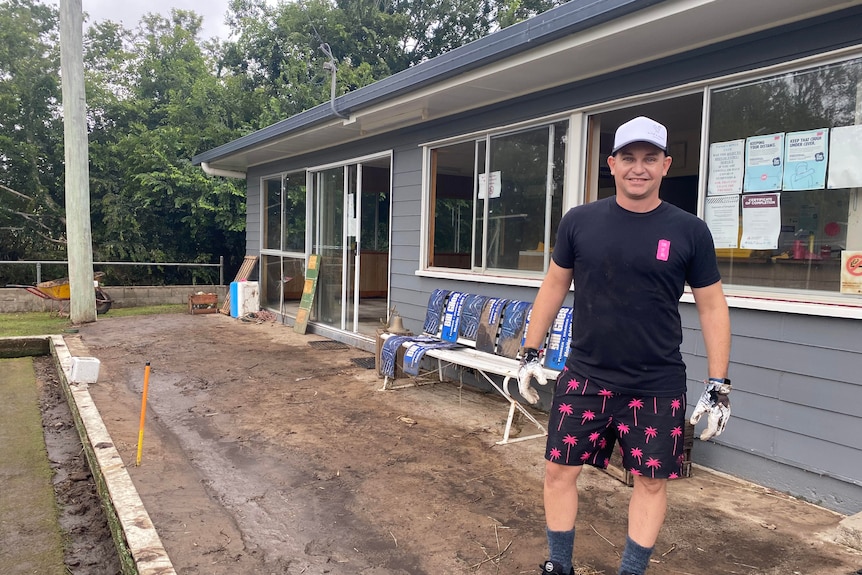 A man standing on muddy ground at the bowls club