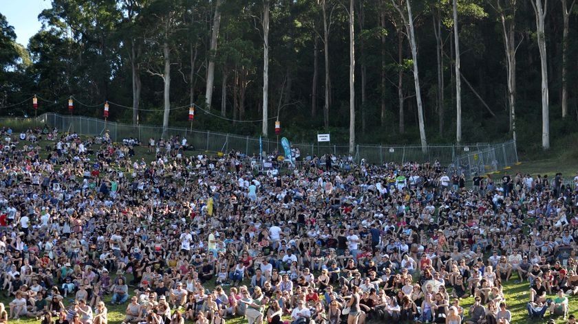 Crowds sit on the hill at the amphitheatre