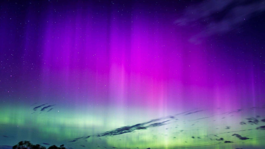 Tall aurora beams stretch high over Carlton, Hobart.