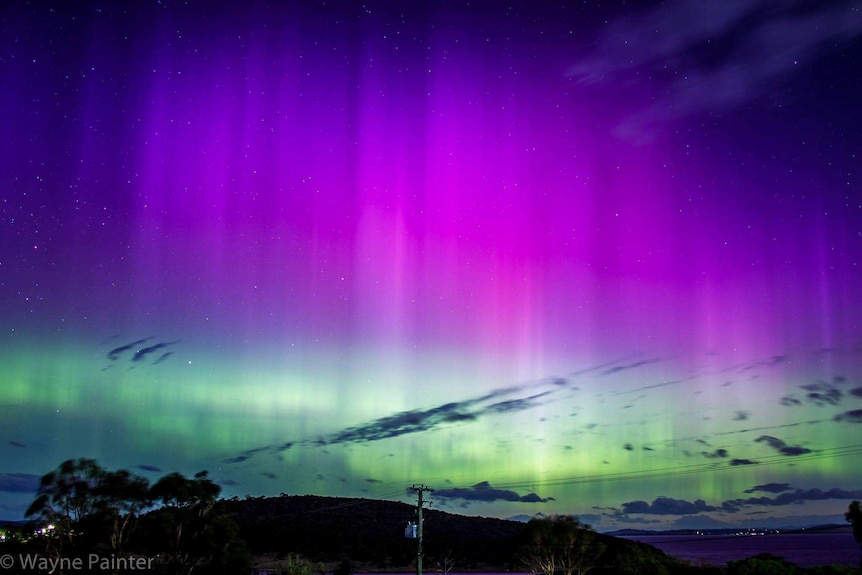 Tall aurora beams stretch high over Carlton, Hobart.