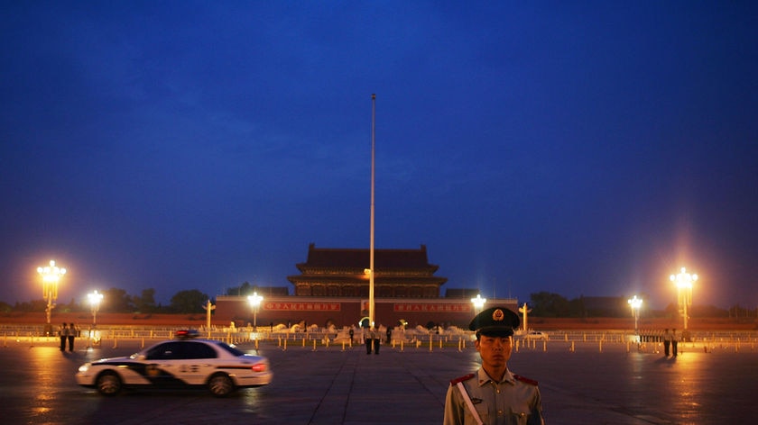 Chinese police stand guard ahead of a Chinese national flag raising ceremony at Tiananmen Square