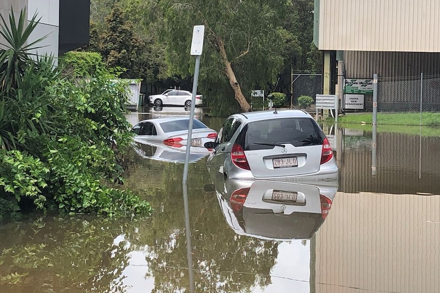 Two silver cars in floodwater