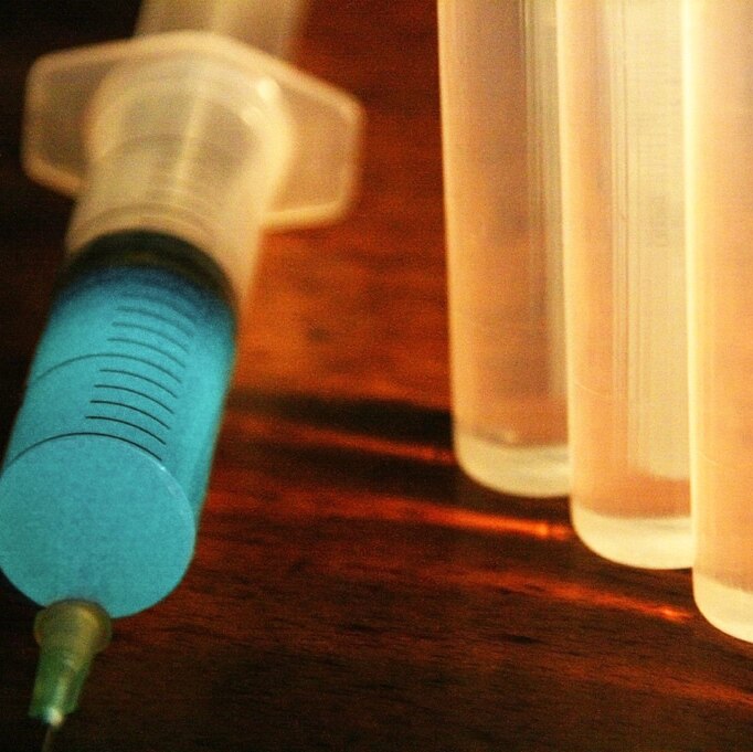 A Syringe and several vials, backlit
