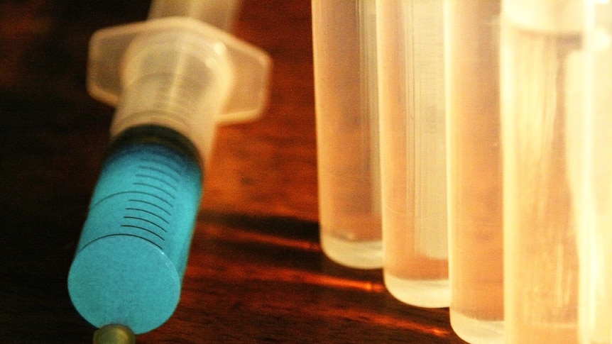 A Syringe and several vials, backlit