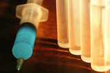 A Syringe and several vials, backlit