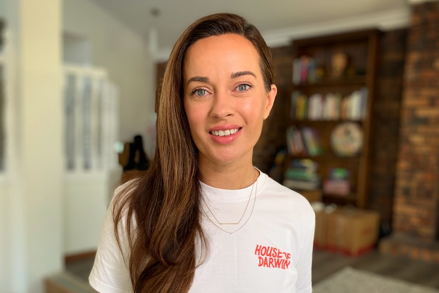 A young brunette woman smiles at the camera