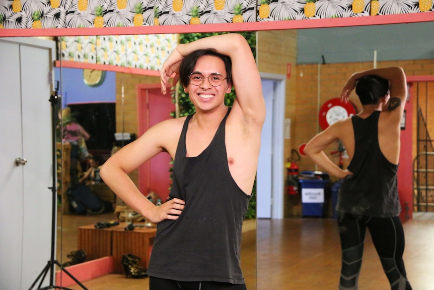 Colour photograph of Beyonce fan and dancer Adam posing in front of a mirror in a dance studio.