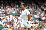 Male tennis player dressed in white walks on court.