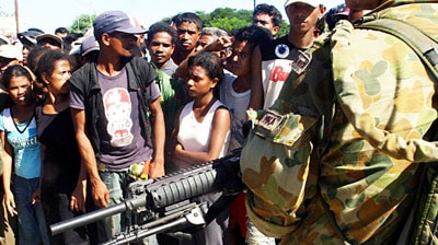 Australian soldiers guard East Timorese people as they queue for rice in Dili.