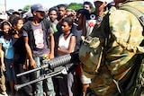 An Australian troop guards East Timorese people as they queue for rice in Dili.