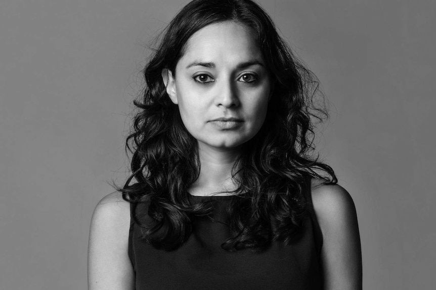 A black and white portrait of the writer standing against a neutral backdrop, her hair shoulder-length over a sleeveless dress.