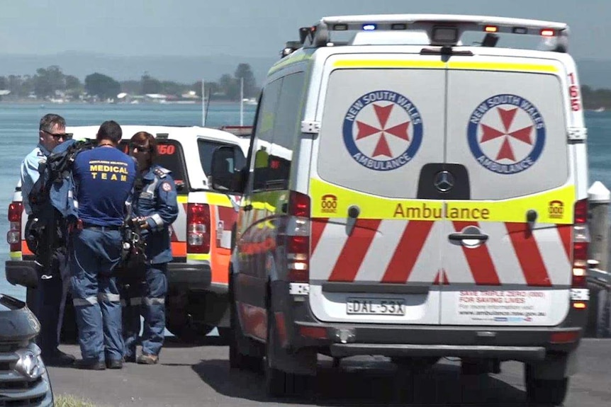 Ambulance and emergency workers in front of the ocean.