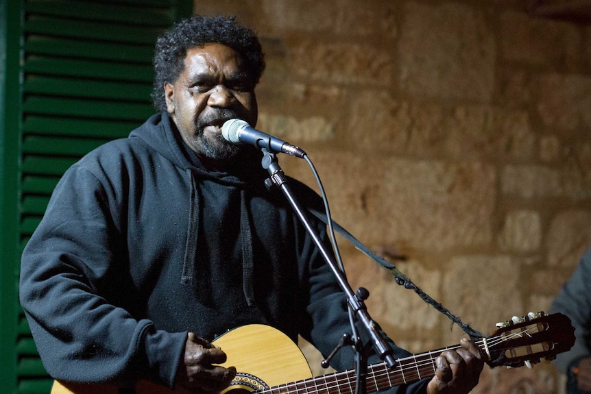 Aboriginal elder James Minning playing guitar during a concert in Coolgardie with The Desert Stars.