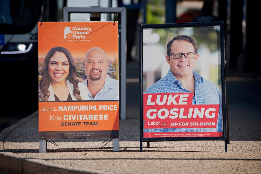 Two election signs stand side by side on a city street 