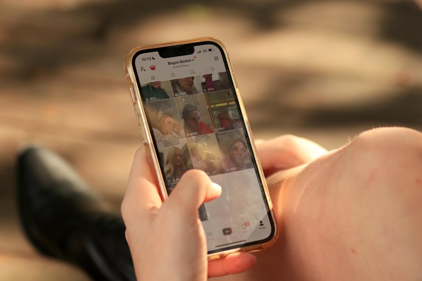 A close up photo of a thumb scrolling the Tik Tok app on an iphone.