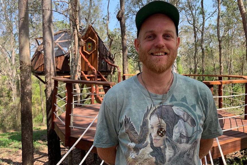 A man standing in front of a self-built tree house
