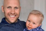 Gary Ablett holds his son and smiles at the camera