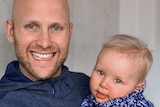 Gary Ablett holds his son and smiles at the camera
