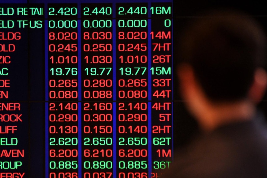 City office-workers and passers-by watch the ASX board in Sydney