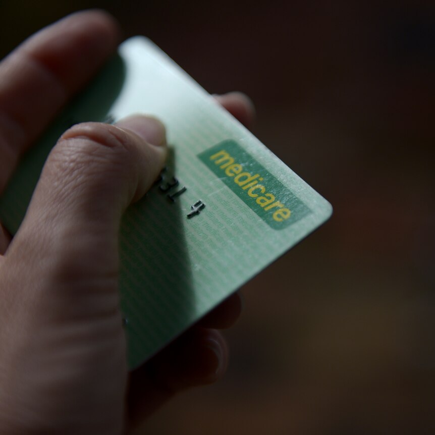 A hand holds a medicare card