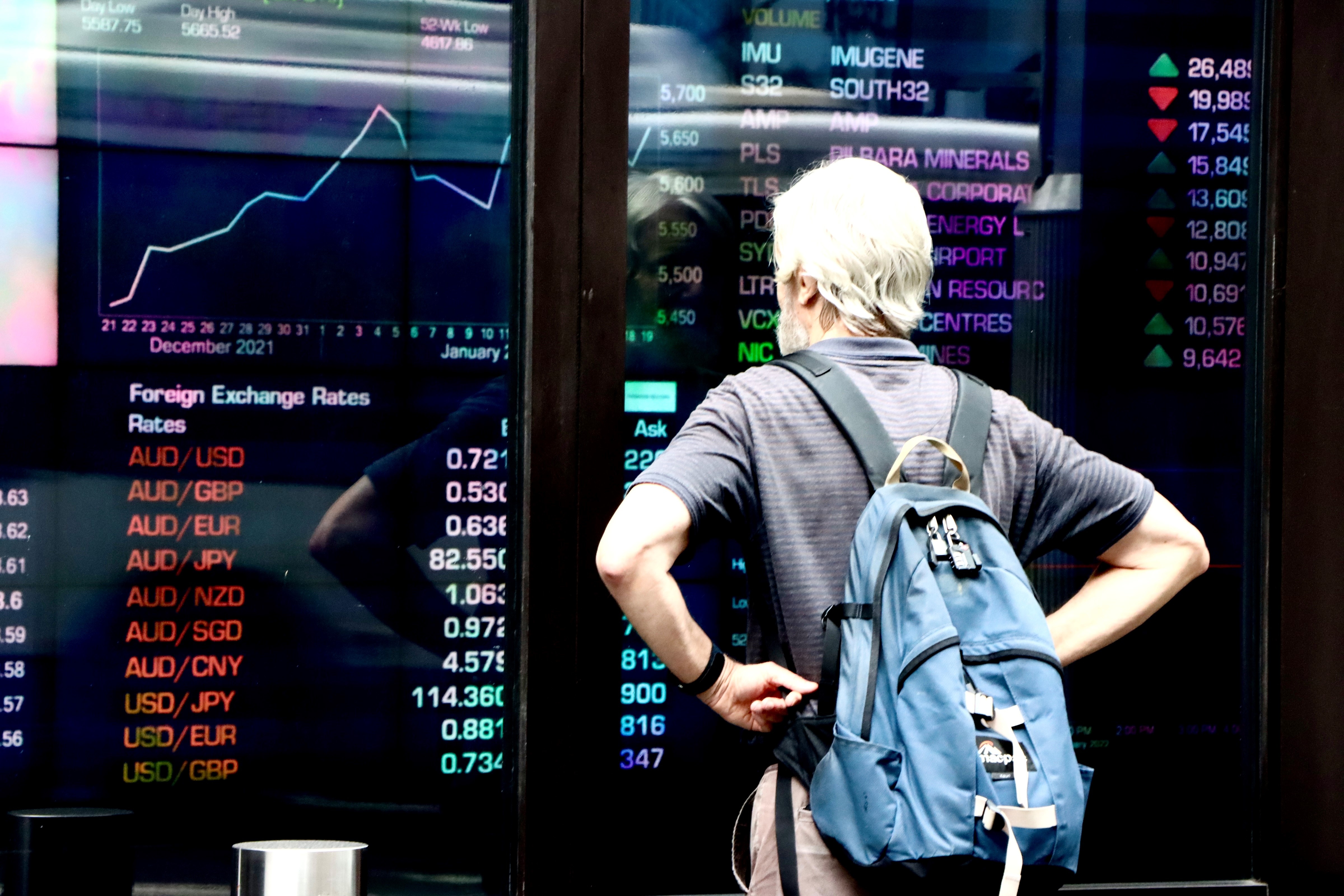 A man looks at stock prices through the window of the ASX in Sydney.