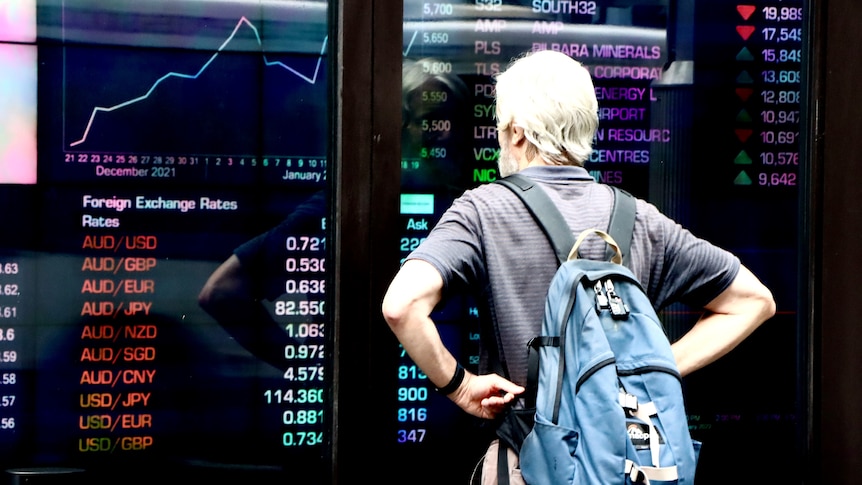 A man looks at stock prices through the window of the ASX in Sydney.