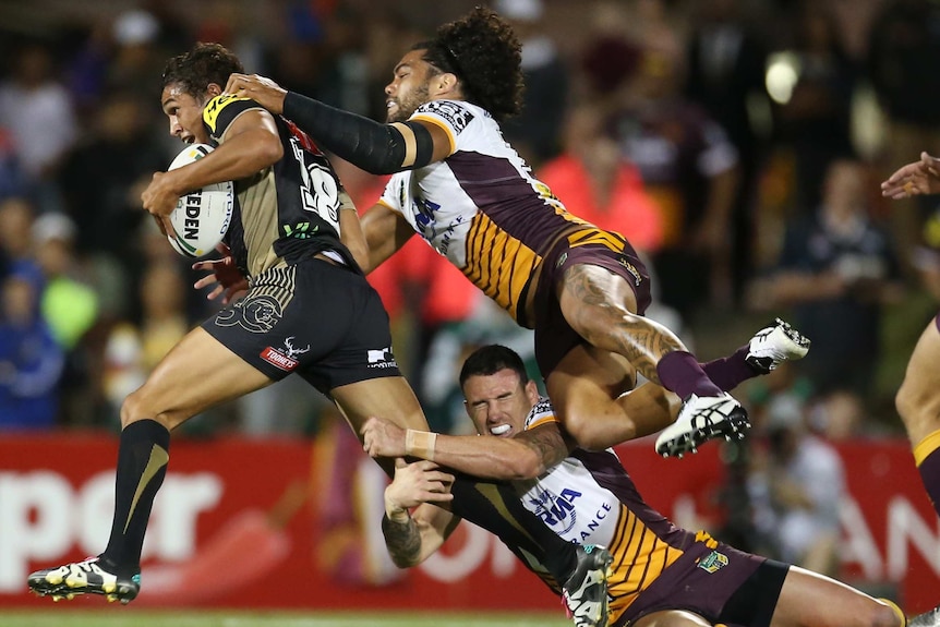 Adam Blair of the Broncos tackles Te Maire Martin of the Panthers