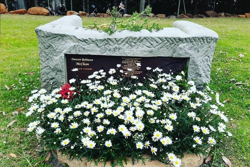 A grave site with flowers out the front.